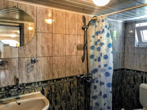 a bathroom with a sink and a shower curtain at Villa Bianca in Balchik