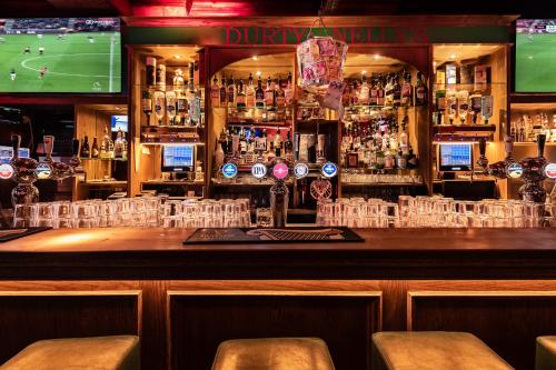 a bar with a football game on a tv in a bar at Durty Nelly's Inn in Amsterdam