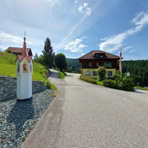 uma estrada que leva a um edifício com uma igreja em Landgasthof Hasbauer em Klein Sankt Paul