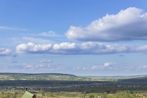 a blue sky with clouds over a green field at Noclegi u Banysia w sercu Gór Świętokrzyskich in Krajno Pierwsze