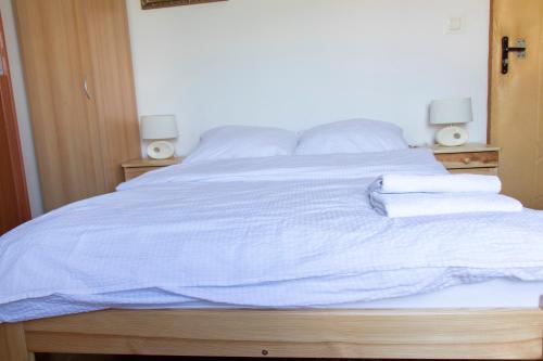 a bed with blue sheets and towels on it at Noclegi u Banysia w sercu Gór Świętokrzyskich in Krajno Pierwsze