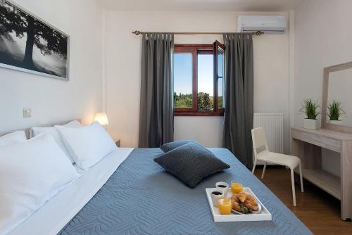 ein Schlafzimmer mit einem Bett und einem Tablett mit Essen drauf in der Unterkunft Adonis Villa in Dassia