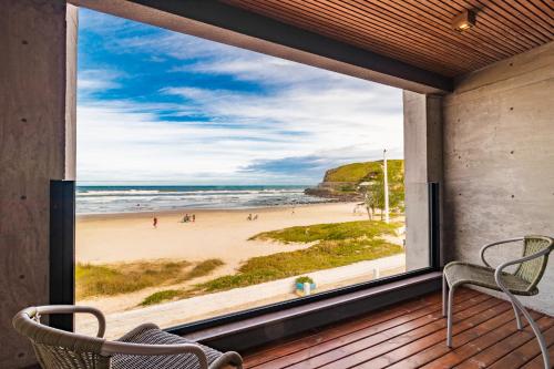 a view of the beach from the porch of a beach house at BALUARTE POUSADA in Torres