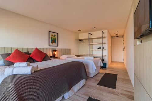 a hotel room with two beds and a television at BALUARTE POUSADA in Torres
