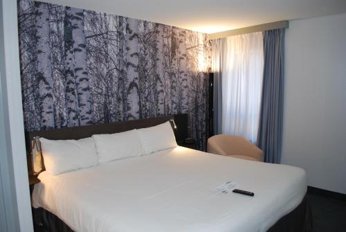 a hotel room with a white bed and white walls at Novotel Ottawa City Centre Hotel in Ottawa