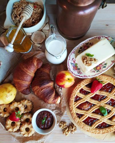 a table topped with bread and pastries and milk at B&B Dolomitincanto in Cesiomaggiore