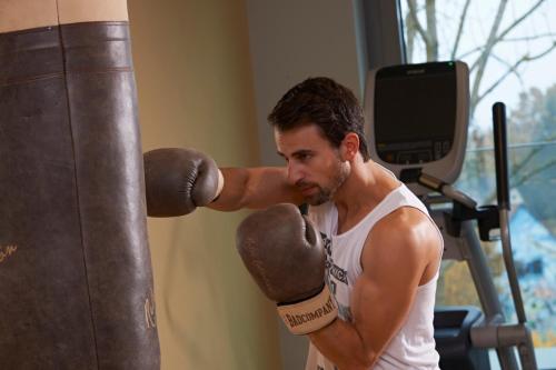 a man is standing next to a punching bag at Hotel FREIgeist Einbeck BW Signature Collection in Einbeck