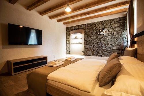 sypialnia z łóżkiem i telewizorem na ścianie w obiekcie Residence Klažary u Žumberka w mieście Kamenná