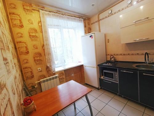 ヤロスラヴリにあるApartment on prospekt Lenina 53のキッチン(木製テーブル、冷蔵庫付)