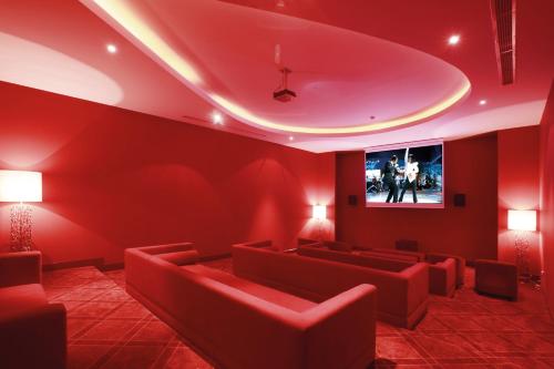 a red waiting room with red chairs and a flat screen tv at Hillstone Bodrum Hotel & Spa in Bodrum City