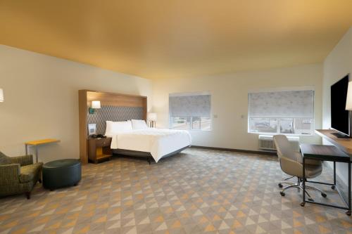 Un pat sau paturi într-o cameră la Holiday Inn & Suites Memphis Southeast-Germantown by IHG
