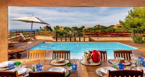 a pool with a table and chairs and a swimming pool at Costa Paradiso Resort in Costa Paradiso