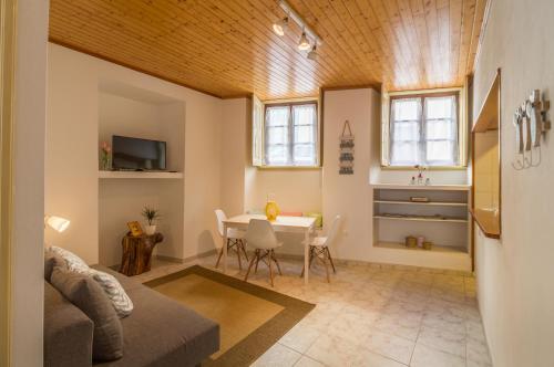 a living room with a table and a dining room at Casa confortável no centro da cidade in Figueira da Foz