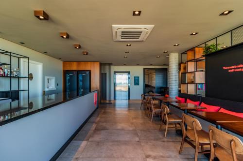 a bar with tables and chairs in a restaurant at BALUARTE POUSADA in Torres