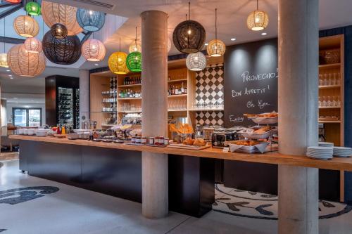 a restaurant with a counter with food and lights at Hôtel Villa KOEGUI Bayonne in Bayonne