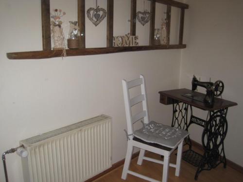 a room with a chair and a table with a sewing machine at Ferienhaus Becker in Rödental