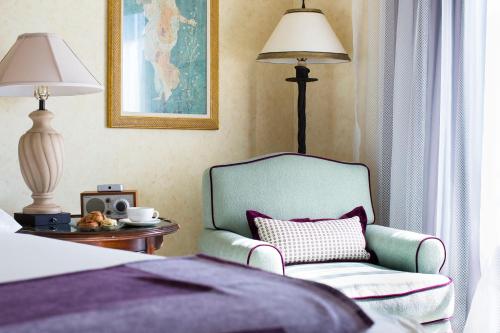 a bedroom with a bed and a chair and a table at Delamar Greenwich Harbor in Greenwich