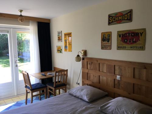 a bedroom with a bed and a desk and a table at Carels Kamers Texel in De Koog