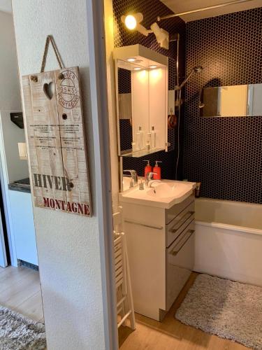 une salle de bain avec un lavabo, un miroir et une baignoire dans l'établissement Studio Turquoise quartier Grattague vue MontBlanc, à Saint-Gervais-les-Bains