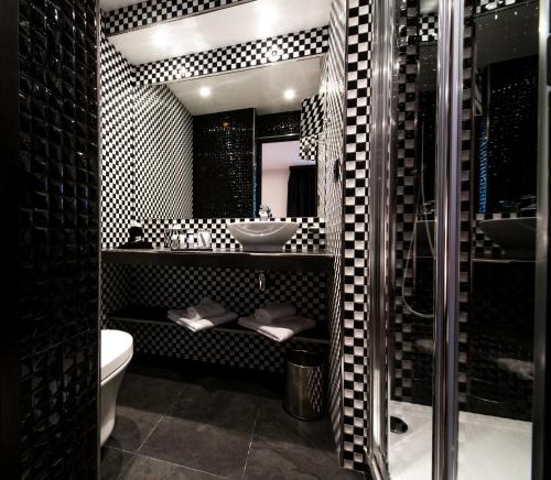 a bathroom with a shower and a sink and a toilet at Hotel Splendor Elysées in Paris