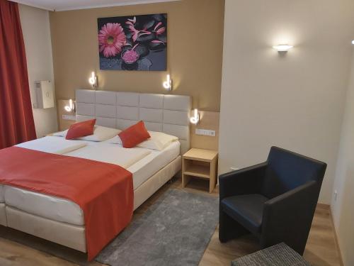 een slaapkamer met een bed en een stoel erin bij Appartement Aragia in Klagenfurt