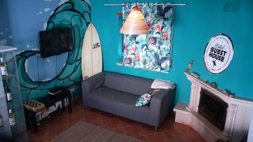 a living room with a couch and a surfboard on the wall at Baleal GuestHouse in Baleal