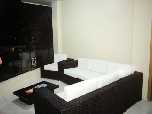 a living room with a white couch and a table at Hotel La Laguna Galapagos in Puerto Villamil