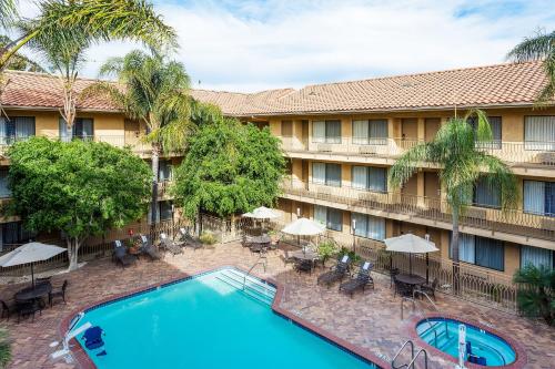 ein Bild eines Hotels mit einem Pool, Tischen und Sonnenschirmen in der Unterkunft Holiday Inn Express Simi Valley, an IHG Hotel in Simi Valley