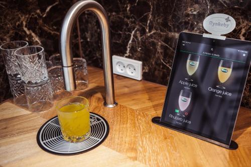 a tablet sitting on a counter with a glass of orange juice at A Hotels Glostrup in Glostrup