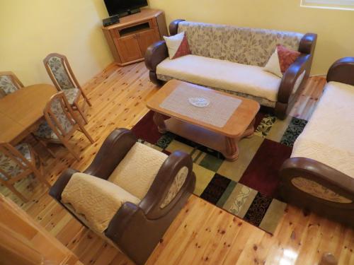 a living room with a couch and a table and chairs at Rooms and Bungalows Sreten Žugić in Žabljak