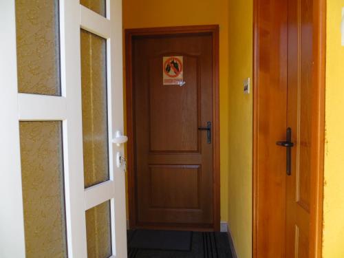 a hallway with a brown door and yellow walls at Rooms and Bungalows Sreten Žugić in Žabljak