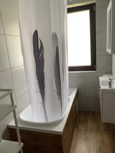 - deux parasols assis dans une baignoire dans la salle de bains dans l'établissement Amelie's House, à Rajcza