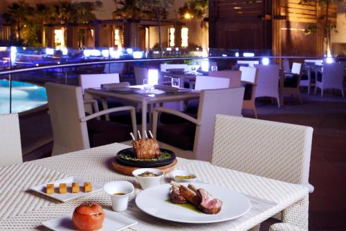 a table with a plate of food on top of a restaurant at Voco - Riyadh by IHG in Riyadh