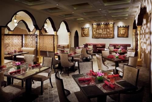 a restaurant with tables and chairs in a room at Voco - Riyadh by IHG in Riyadh