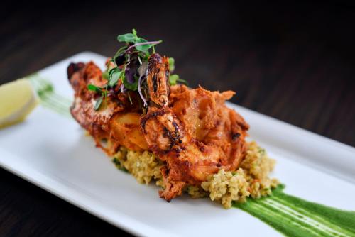 a white plate of food with shrimp and rice at Voco - Riyadh by IHG in Riyadh