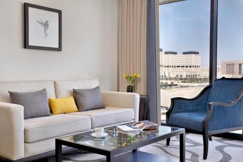 a living room with a couch and two chairs and a table at Voco - Riyadh by IHG in Riyadh
