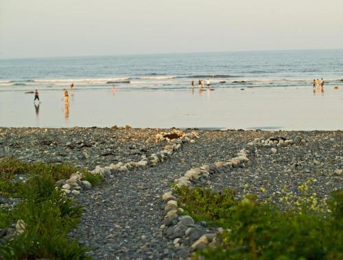 a rocky beach with people swimming in the ocean at Main House at One Long Beach in York Beach
