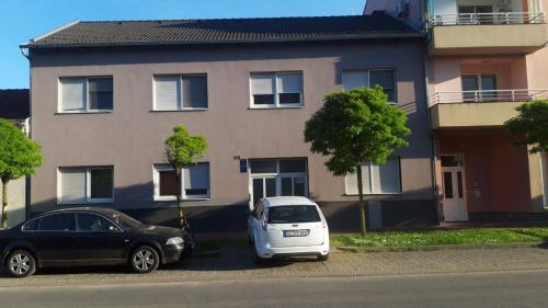 two cars parked in front of a house at Apartment Eurho in Osijek