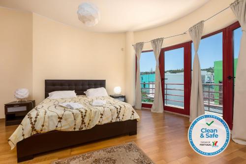 a bedroom with a bed and a balcony at Marina de Albufeira Villa 8 in Albufeira
