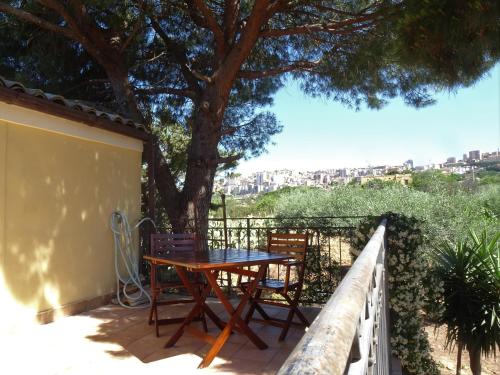 a table and chairs on a balcony with a tree at B&B Villa San Marco in Agrigento