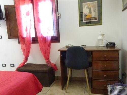 a bedroom with a desk and a chair next to a window at B&B Villa San Marco in Agrigento