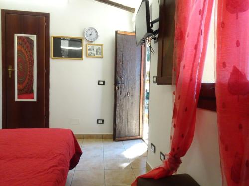 a bedroom with a red bed and a door at B&B Villa San Marco in Agrigento