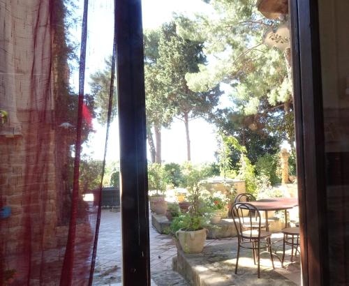 a window view of a patio with a table and chairs at B&B Villa San Marco in Agrigento