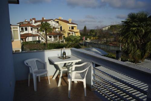 a table and chairs on a balcony with a view at Apartments & Rooms BARBARA in Umag