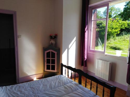 een slaapkamer met een bed en een raam bij chez Patricia in Cransac