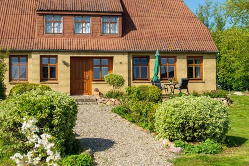 Behrendorf的住宿－Haus Tilde，黄色的房子,有红色的屋顶和花园
