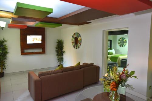 a living room with a couch and a bedroom at Baja Inn Hoteles Rio in Tijuana