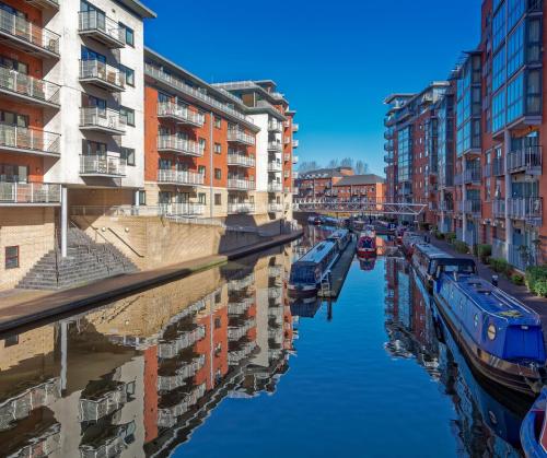 a canal with buildings and boats in a city at Crowne Plaza Birmingham City by IHG in Birmingham