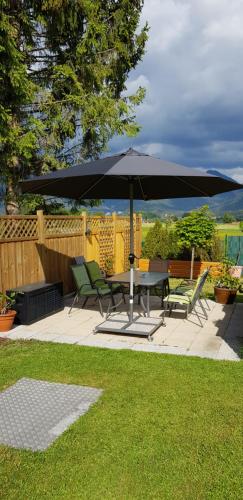 a patio with a table and chairs under an umbrella at Haus Sonnblick in Wangle