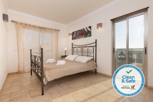 阿尔布费拉Moradia Ricardo - Praia da Gale的一间卧室，里面有一张床和一扇大窗户。